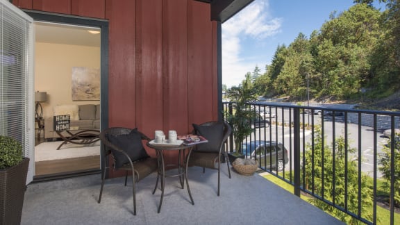 a patio with a table and chairs on a balcony overlooking a river