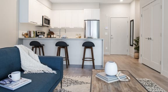 a living room with a couch and a kitchen with a bar