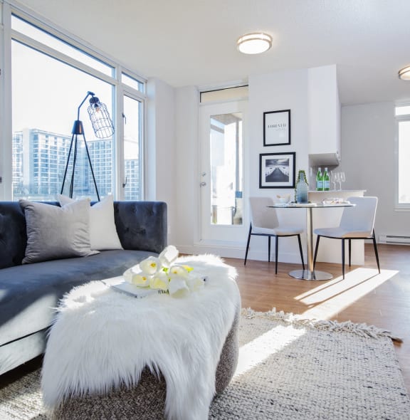 a living room with a black couch and a white ottoman
