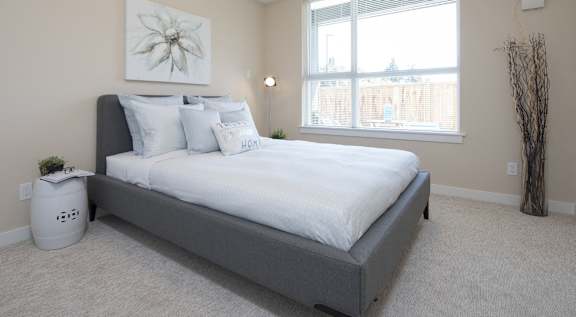 A bedroom with a large bed and a window.