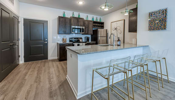 a kitchen with bar stools in front of a counter top at Retreat at Arden Farms, North Carolina