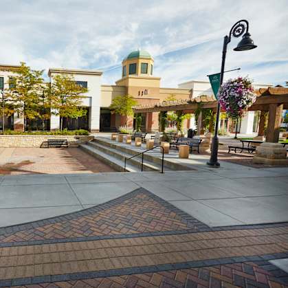 A fountain in the middle of a plaza with a building in the background.