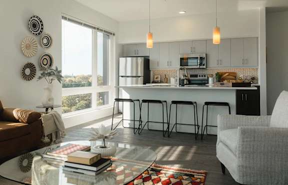 a living area with a kitchen and a large window