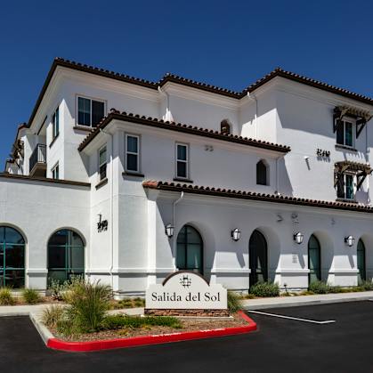 A white building with the name Salida del Sol on it.