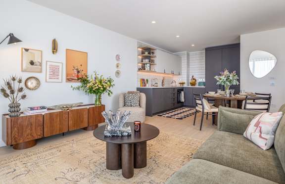 A living room with a brown coffee table and a green couch.