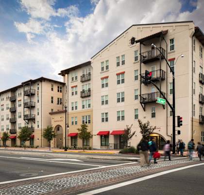 people crossing the street in front of an apartment building