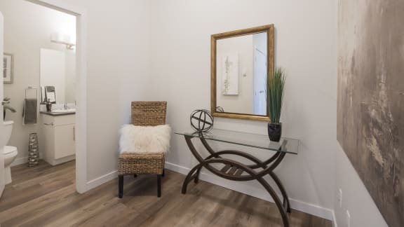 a room with a glass desk with a chair and a mirror