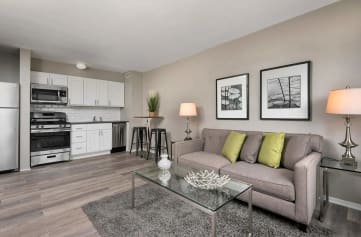 a living area with a couch coffee table and a kitchen in the background at 5550 S Dorchester, Chicago, 60637