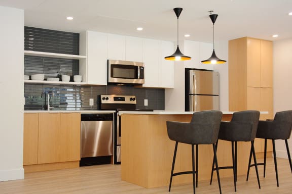 a modern kitchen with a bar and stools