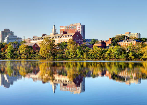 A serene lake with a cityscape reflected in its calm waters.