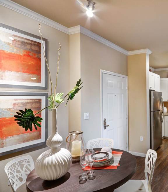 A modern kitchen with a dining table set for two.