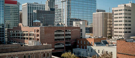 A cityscape with a mix of modern and older buildings under a clear sky.