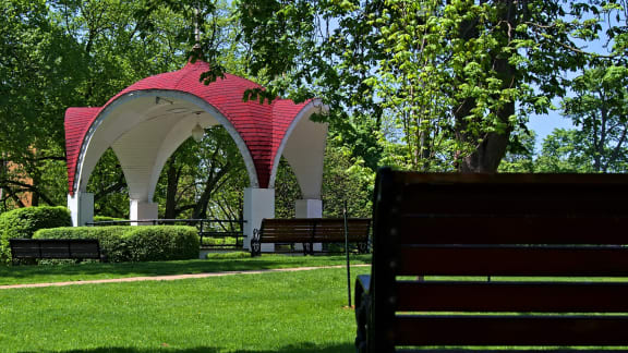a park with benches and a red and white gazebo