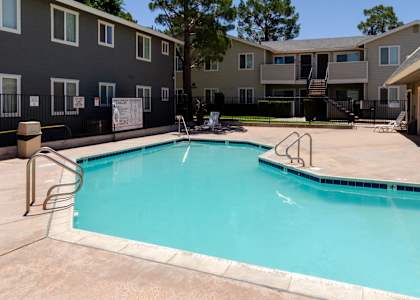 our apartments have a swimming pool with a fence and apartment buildings at Aspire High Desert Apartments, Victorville, CA