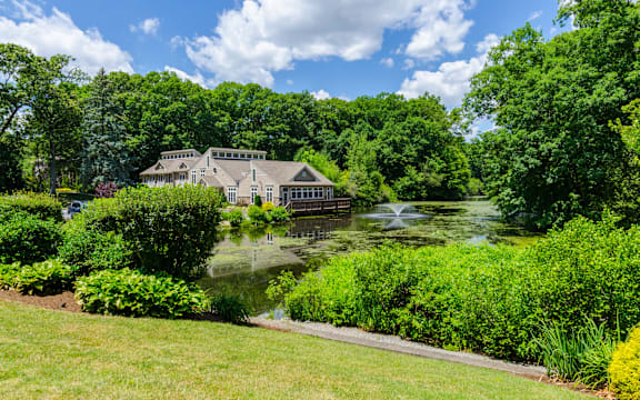 a house on the water with a pond in front of it
