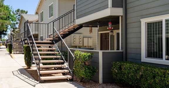 an exterior view of a gray house with stairs at Aspire High Desert Apartments, CA, 92392
