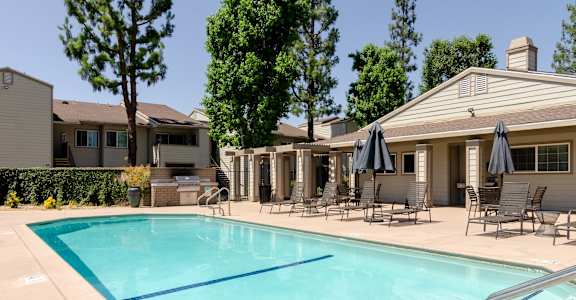 our apartments have a resort style pool with chairs and umbrellas at Aspire Rialto, Rialto, CA, 92376