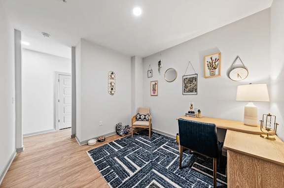 A room with a blue chair and a desk with a lamp on it
