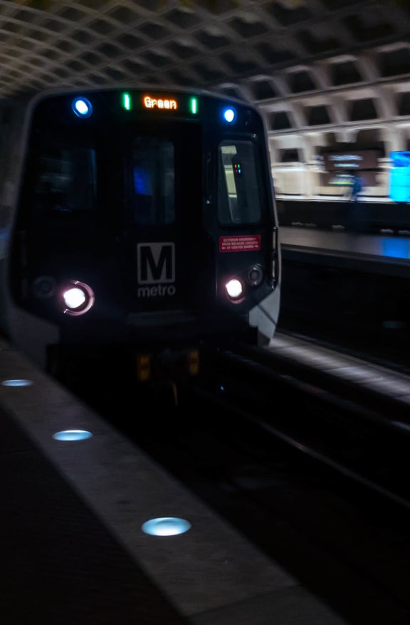 a subway train pulling into a subway station at night