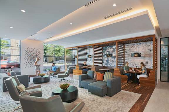 A modern living room with people sitting and chatting.