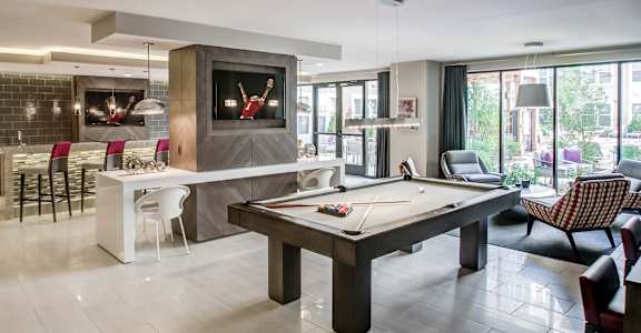 A room with a pool table and a television.