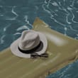 A hat, sunglasses and a bag float on a pool.