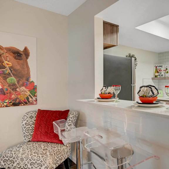 A kitchen with a white counter and a painting of a camel on the wall. at Solstice Apartment Homes, Nevada, 89108