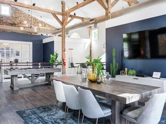 A dining room with a wooden table and chairs.