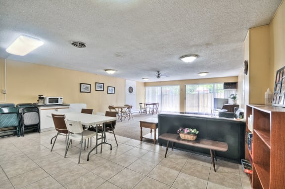 a dining area with a table and chairs and a kitchen with a sink and a