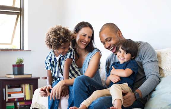 a family sitting on a couch with two children