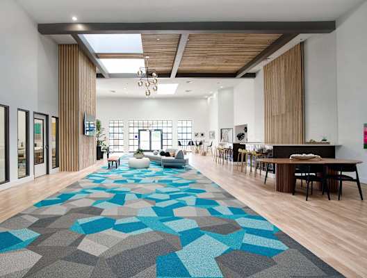 a large lobby with a geometric rug in the middle of it at Presidio Palms Apartments, Tucson
