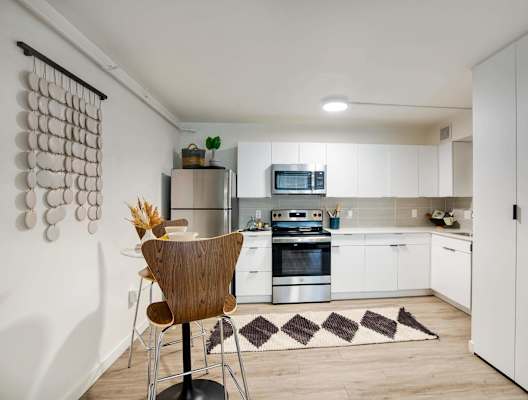 A kitchen with a white cabinet and a wooden chair at Presidio Palms in Tucson, AZ