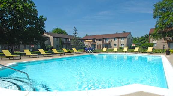 a swimming pool with yellow lounge chairs around it