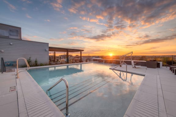 a swimming pool with a sunset in the background at a hotel