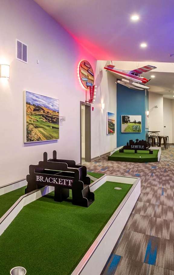 A pool table in a room with a blue wall and a picture of a pool table.