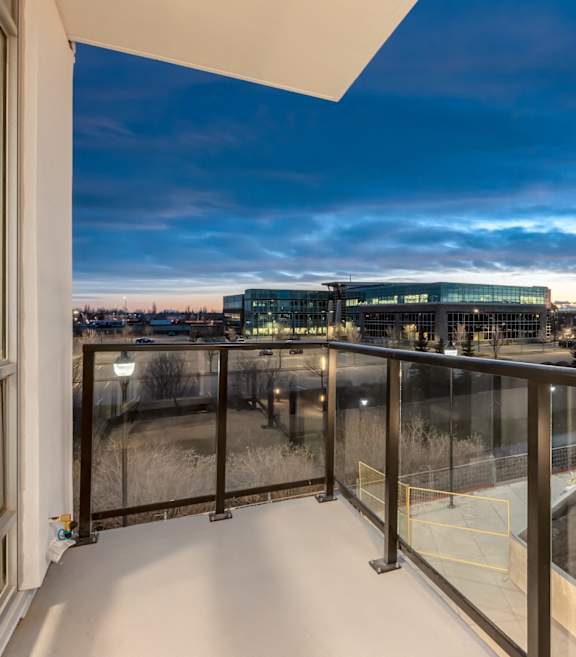 A balcony with a view of a cityscape at dusk.