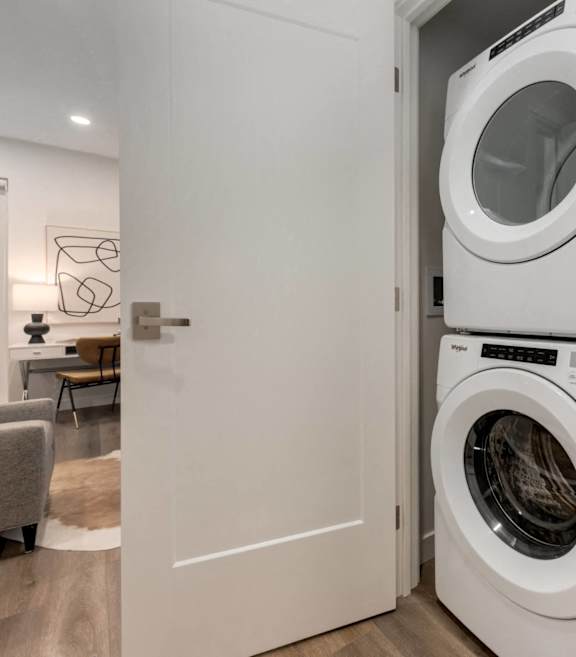 A white washing machine is in a small laundry room.