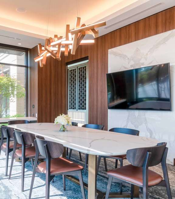 A dining room with a large table and chairs.