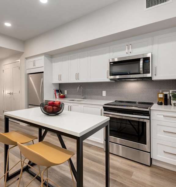 A modern kitchen with a white table and chairs.