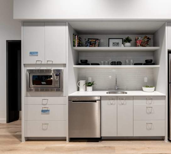 A modern kitchen with a refrigerator, oven, and sink.
