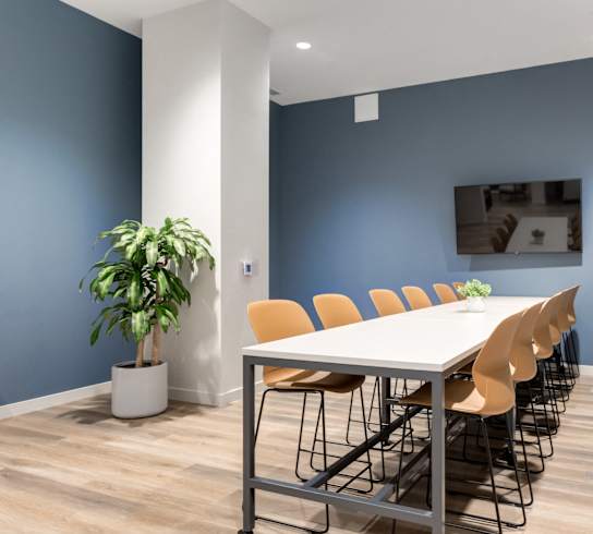 A conference room with a long table and chairs.