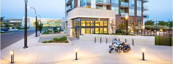 A motorcycle is parked on a concrete area in front of a building.