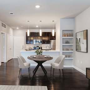 A modern kitchen with a dining table set for two.