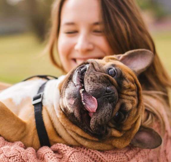 a woman holding a dog in her arms