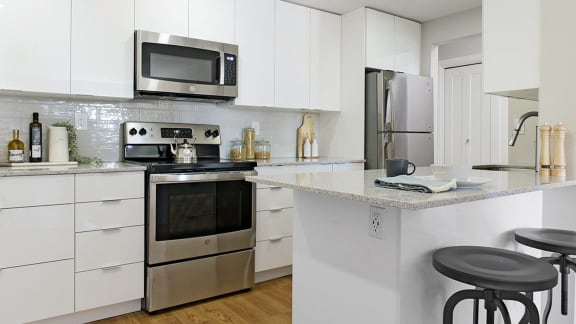 a kitchen with white cabinets and stainless steel appliances