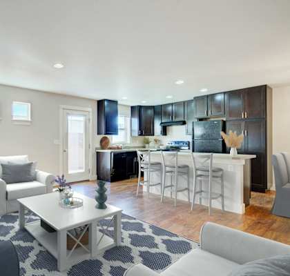 a living room with couches and a coffee table in front of a kitchen at Copper Pines, Bozeman