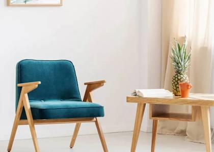 A blue chair and a small table with a pineapple on it.