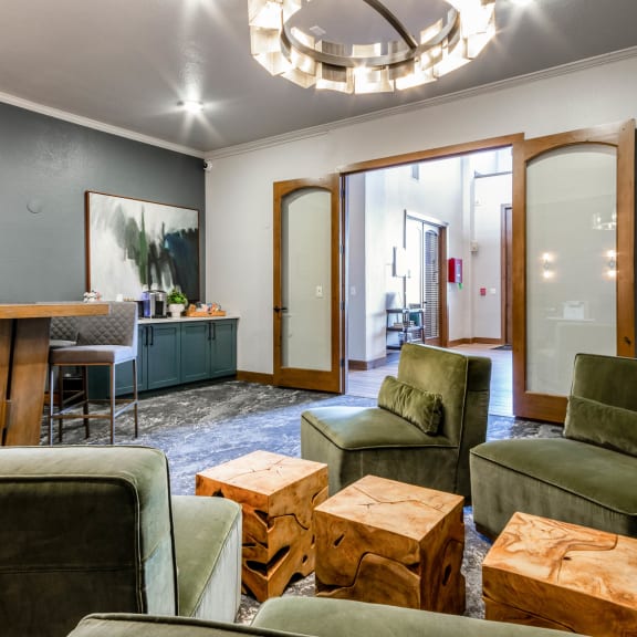 a living room with green couches and chairs and a table at The links at Plum Creek Apartments, Castlerock, 80104