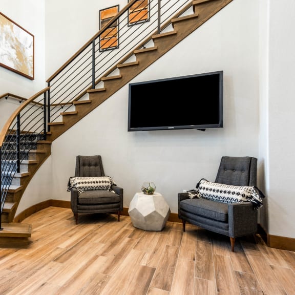 a living room with a staircase and a tv on the wall  at The Links at Plum Creek, Castlerock, CO