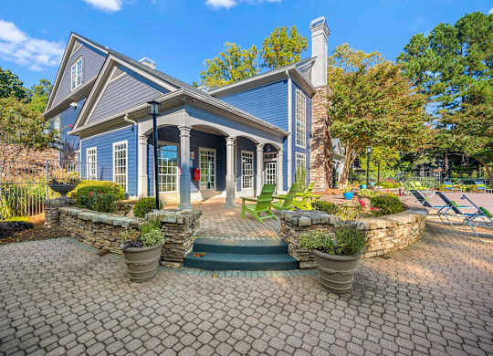 a home with a brick patio and a blue house